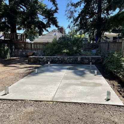 Concrete slab in a landscaped backyard with visible control joints